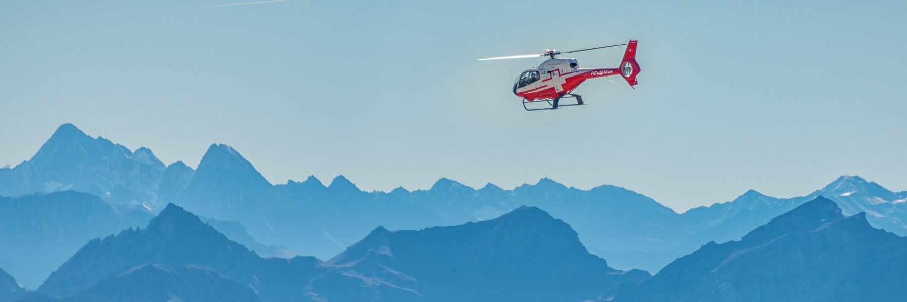 Helicopter flying above the mountains of switzerland